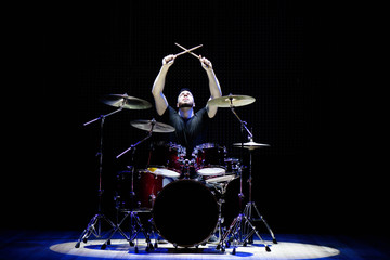 Drummer playing the drums with smoke and powder in the background