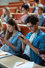 Multi Ethnic Group of Students Using Smartphones During the Lecture. Young People Using Social Media while Studying in the University.