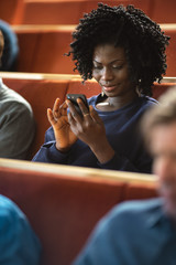 Beautiful Young Black Girl Using Smartphones During the Lecture. Young People Using Social Media while Studying in the University.