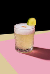 Pisco Sour, cocktail IBA with Pisco, lime or lemon juice, egg white, and angostura. Dark background, pop contemporary style.