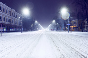 Main street with cars and snow at night