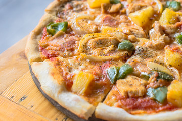 Fresh pizza with tomatoes, cheese and mushrooms on wooden table