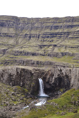 Fototapeta na wymiar Icelandic mountain high waterfall under the sun