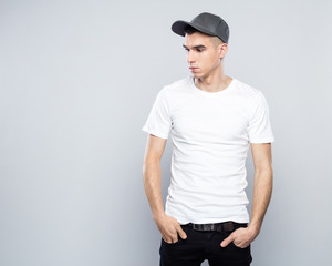 Portrait of cool young man in baseball cap and white t-shirt
