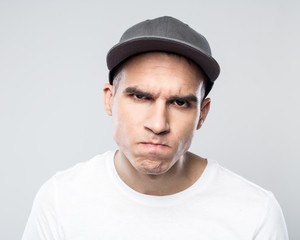 Portrait of angry young man in baseball cap