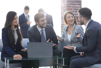 Beautiful business people are using gadgets, talking and smiling