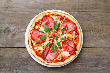 Hot spicy Italian pizza with salami and gherkins, delicious meals for foodie. Restaurant, pizzeria, family cuisine concept
