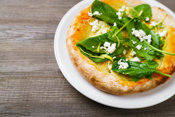Italian appetizer, snack, banquet, family restaurant menu concept. Delicious focaccia with cottage cheese ans spinach leaves on restaurant table