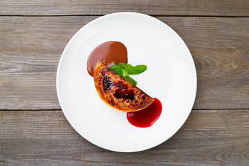 Sweets, pastry, confectionery, restaurant menu. Cheesecake with strawberry and chocolate sauce on porcelain plate, flat lay