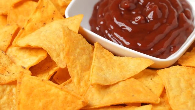 Close up of rotating nacho chips with salsa. No sound.