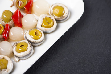 Banderillas of olives with spring onion and anchovies on a white plate. Typical spanish food.