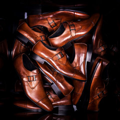 Brown men's monk shoes on black background with reflection. Fashion advertising shoes photos.