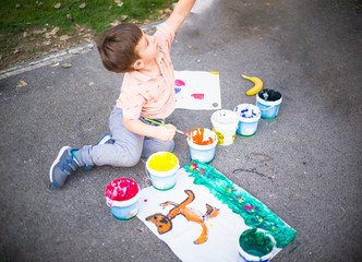 Naklejka premium Portrait of a little boy enjoying his painting