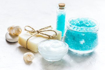 Fototapeta na wymiar blue sea salt, soap and body cream on stone desk background