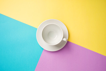 white empty coffee Cup on bright yellow-turquoise-purple background. copy spase, flat lay