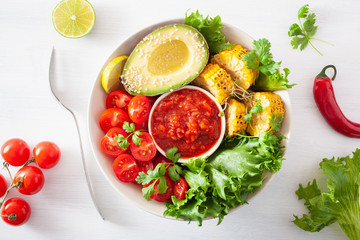 vegan buddha bowl. healthy lunch bowl with avocado, tomato, sweet corn and salsa