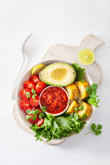 vegan buddha bowl. healthy lunch bowl with avocado, tomato, sweet corn and salsa