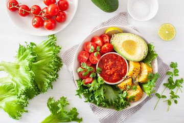 vegan buddha bowl. healthy lunch bowl with avocado, tomato, sweet corn and salsa