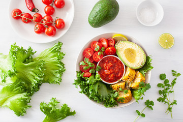 vegan buddha bowl. healthy lunch bowl with avocado, tomato, sweet corn and salsa