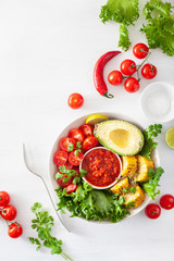vegan buddha bowl. healthy lunch bowl with avocado, tomato, sweet corn and salsa