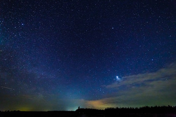 Starry sky and illuminated clouds.