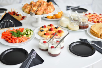 Beautiful european breakfast. A lot of food. Cakes and drinks. White table. 