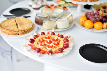 Beautiful european breakfast. A lot of food. Cakes and drinks. White table. 