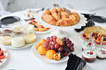 Beautiful european breakfast. A lot of food. Cakes and drinks. White table. 
