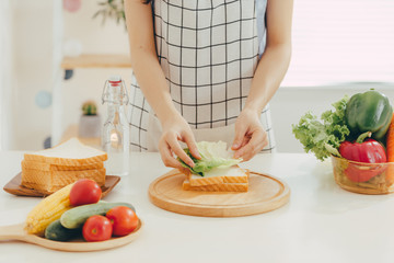 Young woman cutting vegetables in kitchen
