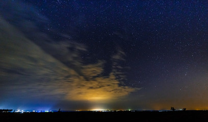 Fototapeta na wymiar Starry sky and illuminated clouds.