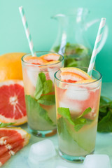 Refreshment grapefruit cocktail with mint on mint color background. Healthy citrus summer drink. Toned