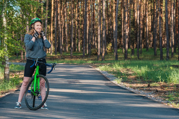 Fototapeta premium Girl on a bicycle in the park. A racing bicycle. Active way of life and playing sports.