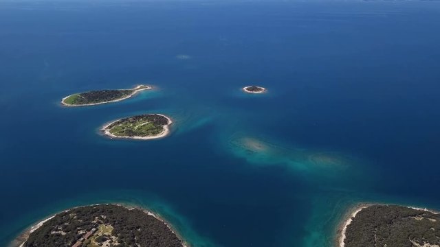 Flight over small desert islands and colorful sea, Brijuni park, Croatia