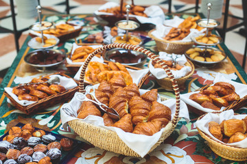 Table de banquet de restauration joliment décorée avec une variété de pâtisseries et de boulangeries différentes, avec des croissants et des biscuits lors d& 39 une fête d& 39 anniversaire de Noël d& 39 entreprise ou d& 39 une célébration de mariage