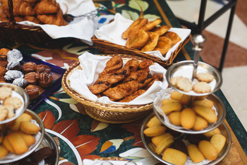 Beautifully decorated catering banquet table with variety of different pastry and bakery, with croissants and cookies on corporate christmas birthday party event or wedding celebration
