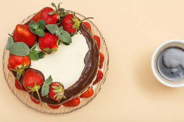 Homemade chocolate cake decorated with fresh strawberries on glass plate
