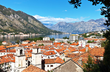 Naklejka na ściany i meble Montenegro. A view from above on the picturesque old town of Kotor with red tiled roofs and blue water of the Boka Kotor Bay on a sunny summer day (protected by UNESCO)