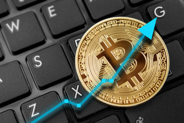 Bitcoin on computer laptop for investing and happiness for financial and business gain concept.  Green up arrow rising prices.