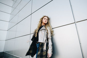 Girl in jacket outdoor near geometry wall