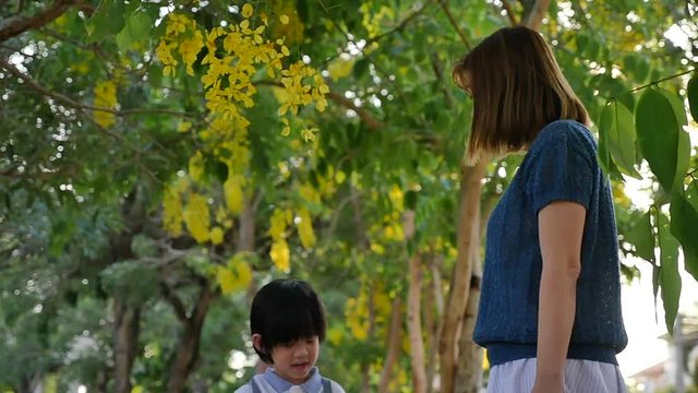Asian mother  playing with her son in the park slow motion 