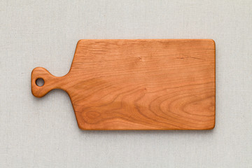Cherry wood cutting board on linen, handmade wood cutting board