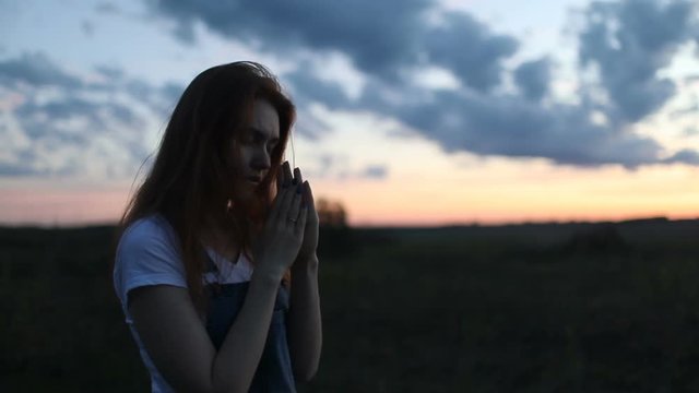 Young woman praying in the morning outdoors