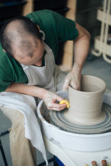 Handcrafted on a potter's wheel,Hands make clay from various items for home and sale in the store and at the exhibition, ceramic items are made in hand, the clay billet becomes a ceramic dish