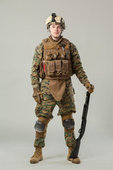 Soldier in camouflage holding rifle