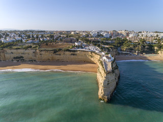 Aerial rocky famous seascape cape and Senhora da Rocha church on top of the cliff, in Algarve.