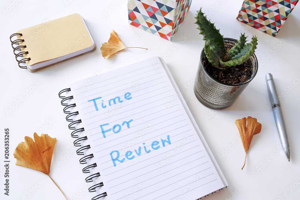 Poster time for review written in notebook on white table