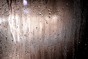 Drops of rain run down my window in the night