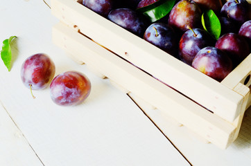 Wooden crate with plums