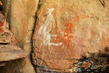 Ancient aboriginal painting art, representing man hunting kangaroo, on huge rock stone in Kakadu...