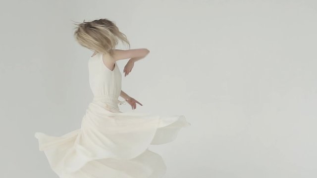 Close-up portrait of a ballerina. young ballet dancer in white fluttering long dress. slow motion